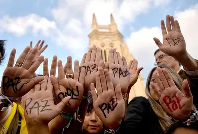 zzzzinte1Supporters of Colombian president and presidential candidate Juan Manuel Santos raise their hands with the word "Peace" written on them during a peace event in Bogota, on June 11, 2014. Colombia's government and the country's second largest guerrilla group, the National Liberation Army (ELN), announced on the eve they have opened peace talks, which adds to those taking place with the FARC, with a tense runoff presidential election just days away. AFP PHOTO/Diana Sanchez
zzzz