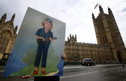 Artist Kaya Mar displays his painting of Britain's Home Secretary Theresa May near parliament in London, Tuesday, July 12, 2016. Theresa May will become Britain's new Prime Minister on Wednesday. (AP Photo/Kirsty Wigglesworth)