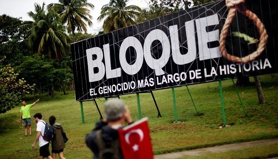 People march by a sign saying, "The embargo: the longest genocide in history," during the 1st of May Labor Day March - a call for people to march in support of their local socialist government and the Cuban Revolution - in Havana, Cuba, on May 01, 2015. The commercial, financial and economic embargo enforced by the United States against Cuba went into effect in 1960, nearly two years after the deposition of the Fulgencio Batista dictatorship by the Cuban Revolution, and just after Cuba nationalized American-owned Cuban properties without remuneration to the States. The embargo at first did not apply to food and medicine, but was quickly broadened to nearly all U.S. exports. Proponents of the embargo cite repeated human rights violations in the country and the appropriated property as reasons to uphold it. Critics define the embargo as too harsh; the UN General Assembly has passed a resolution each year since 1992 criticizing its ongoing impact, citing it to be in violation of the Charter of the UN and international law. In December of 2014, U.S. President Barack Obama signaled an openness in thawing of U.S.-Cuban relations, which started with diplomatic talks and transitioned to the removal of Cuba from the U.S. list of state sponsors of terrorism in May of this year. 