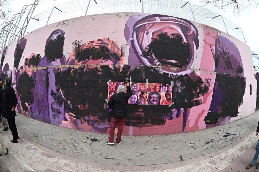 GRAF596. MADRID, 08/03/2021.- Una mujer junto al mural feminista "La unión hace la fuerza" del barrio de Ciudad Lineal (Madrid) que este lunes, Día de la Mujer, ha amanecido vandalizado con pintura negra que cubre los rostros de las mujeres homenajeadas en sus paredes. EFE/ Fernando Villar