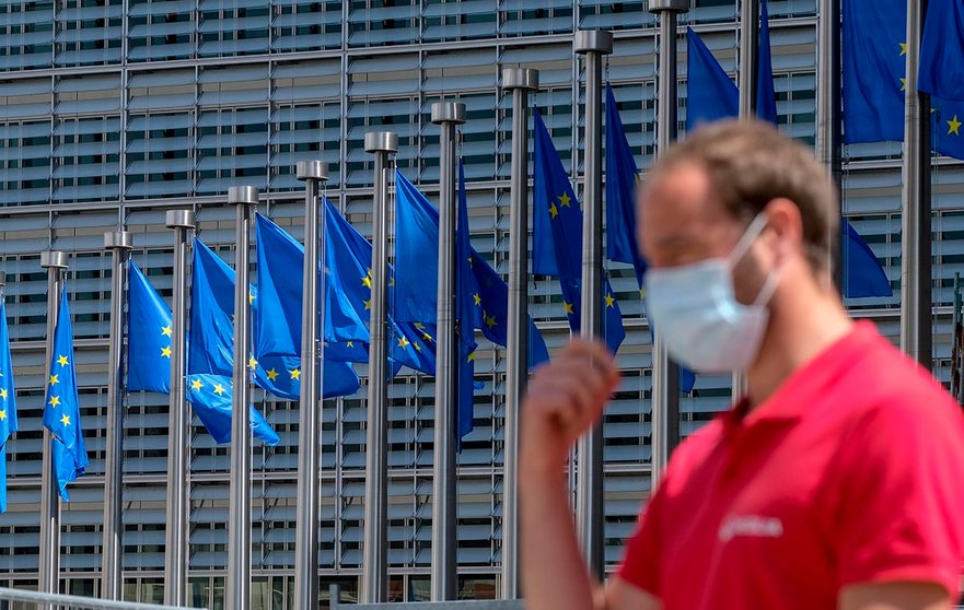 Brussels (Belgium), 25/05/2020.- A man wearing a face mask walks in front of the European Commission flags at the Berlaymont building headquarters in Brussels, Belgium, 25 May 2020. Countries around the world are gradually easing COVID-19 lockdown restrictions in an effort to restart the economy and help people in their daily routines. (Bélgica, Bruselas) EFE/EPA/OLIVIER HOSLET