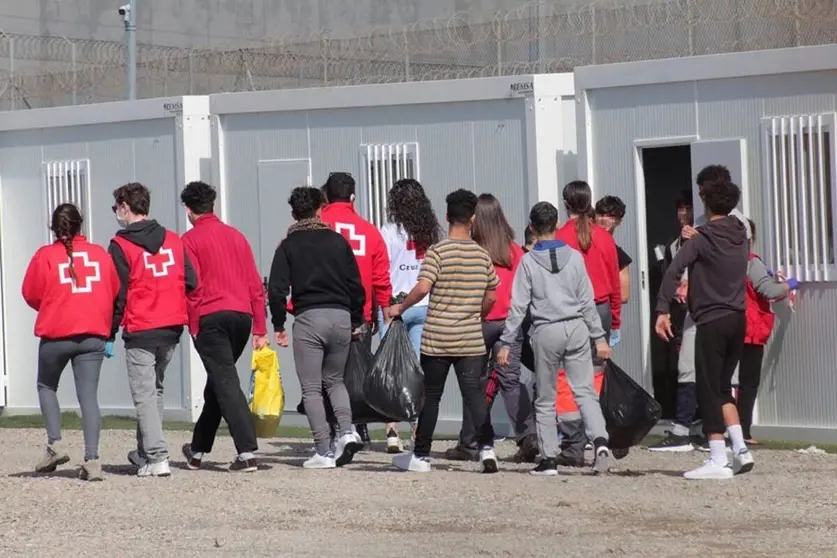 Un grupo de menores extranjeros, acompa&ntilde;ados por voluntarios de la Cruz Roja, llegan a un albergue en Ceuta