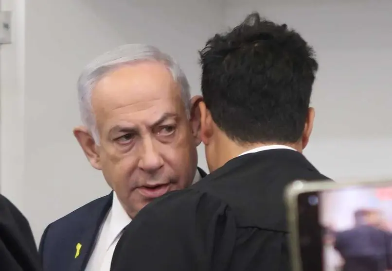 Benjamin Netanyahu en el tribunal durante su juicio por corrupci&oacute;n, antes de su tercer d&iacute;a de testimonios, parece estar hablando con su abogado, Amit Hadad, de espaldas a la c&aacute;mara&nbsp;[1]