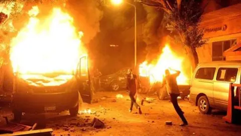 Manifestantes egipcios queman veh&iacute;culos de la Polic&iacute;a durante unas protestas en El Cairo (Egipto), donde un grupo de manifestantes egipcios derrib&oacute; un muro de la Embajada de Israel y parte de un edificio del Ministerio del Interior fue incendiado.