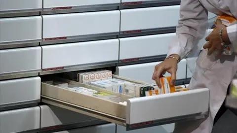 una-farmaceutica-guarda-medicamentos-1442075057987