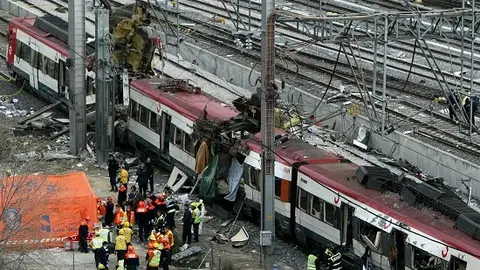 Rescue workers lift  a body bag containing the body of a bomb victim from a train about one kilometer outside the main train station in Madrid, March 11, 2004.  Ten simultaneous explosions killed 182 people on packed Madrid commuter trains on Thursday in Europe's bloodiest attack for more than 15 years.                     REUTERS/Kai Pfaffenbach