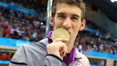 LONDON, ENGLAND - AUGUST 04:  Gold medallist  Michael Phelps of the United States kisses his medal following the medal ceremony for the Men's 4x100m Meldey Relay Final on Day 8 of the London 2012 Olympic Games at the Aquatics Centre on August 4, 2012 in London, England.  (Photo by Al Bello/Getty Images)