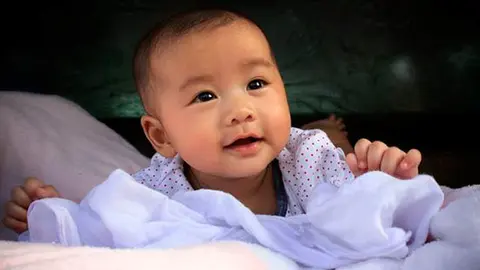 Bebe-asiatico-gesto-sonriente