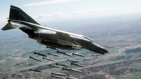 An air-to-air right side view of an 81st Tactical Fighter Squadron F-4E Phantom II aircraft releasing 18 Mark-82 500-pound bombs over the Bardenas Reales Gunnery Range. (U.S. Air Force photo by Staff Sgt. David Nolan)