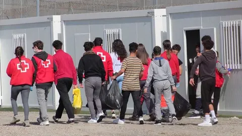 Un grupo de menores extranjeros, acompa&ntilde;ados por voluntarios de la Cruz Roja, llegan a un albergue en Ceuta